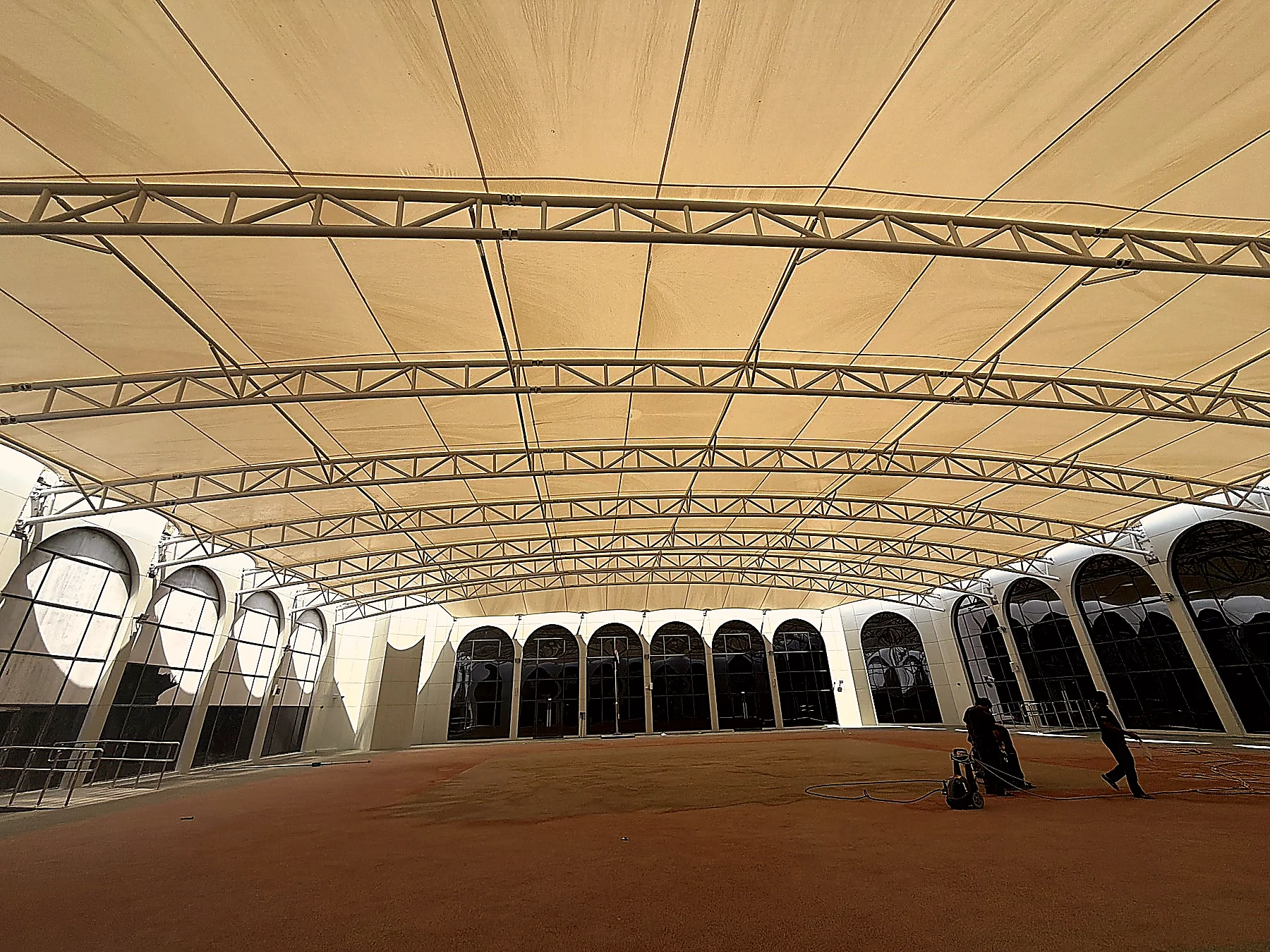 Al Wathba School — tensile-shade covered courtyard, the campus anchor